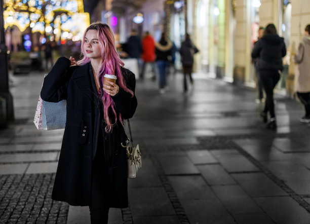 一个女人在城里散步、购物，度过一个美好的夜晚。图片下载