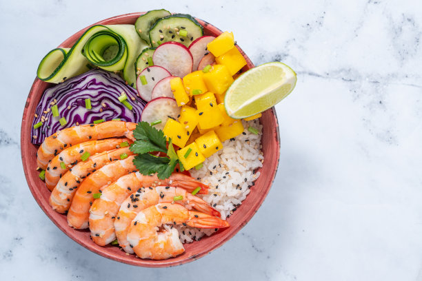虾戳碗在白色大理石与芒果，鳄梨，萝卜，胡萝卜，黄瓜图片下载