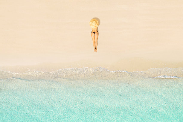 女子在比基尼和草帽躺在热带塞舌尔海滩上晒太阳的俯视图。航拍，无人机视图图片下载