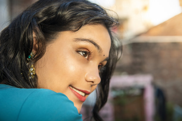 穿着纱丽的美丽快乐的印度女人的肖像，看着别处，思考。图片下载
