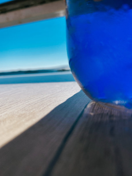 在炎热的夏天，在大海前，一杯水的清爽照片图片下载