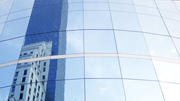 近景现代商业玻璃建筑，蓝天背景。复制布局空间。图片下载