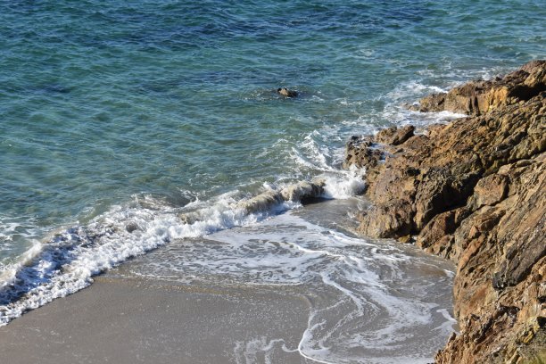 法国布列塔尼的一个有蓝色海水和悬崖的海滩图片下载