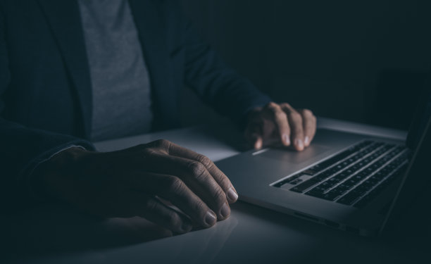 双手在笔记本电脑键盘上打字。在电脑上工作的人。黑暗的情绪。技术、经营理念图片下载