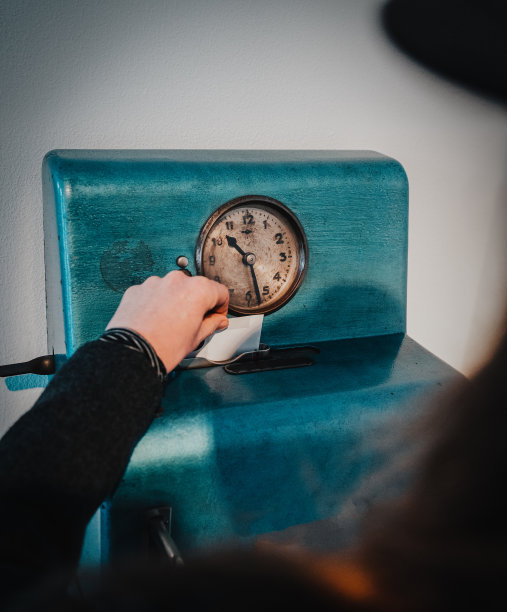 女性的手正在把卡片放进老式的时钟里图片下载