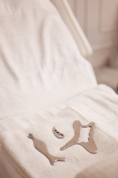 白色的按摩床上放着钢棍。图片下载