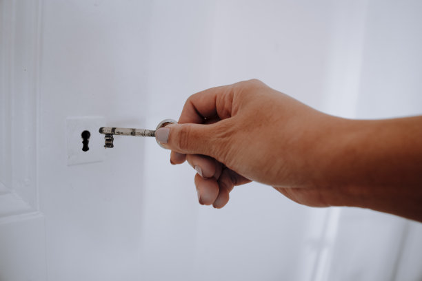 一只手用钥匙开门。图片下载