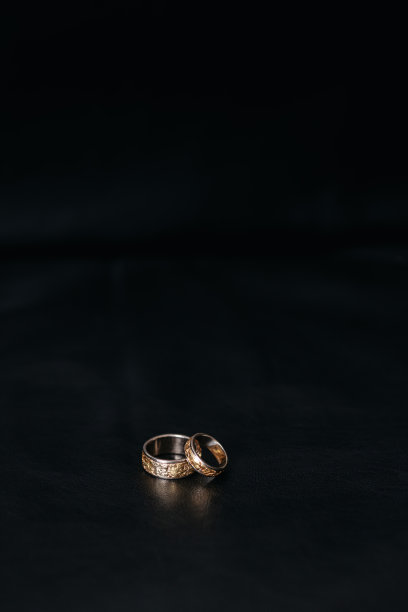 黑色背景上的一对金婚戒。图片下载