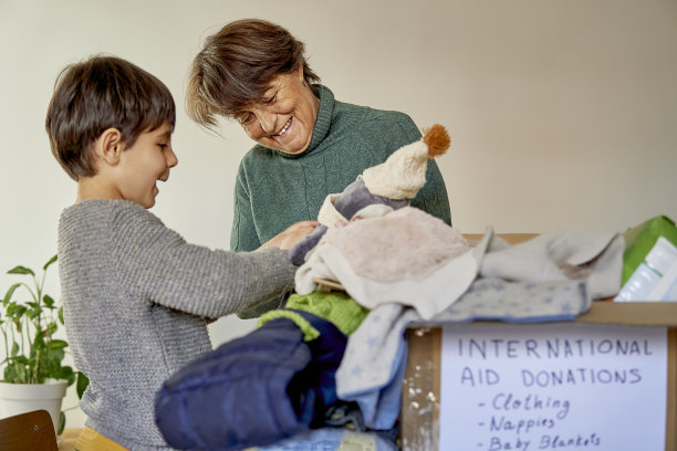快乐的祖母和孙子为自然灾害的国际援助收集物资图片下载