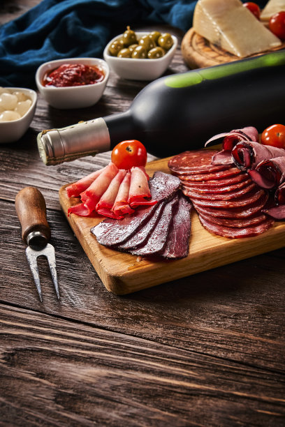 高角度视角的tapas奶酪，腌火腿，意大利腊肠酒和西班牙香肠在一个质朴的木桌复制空间图片下载