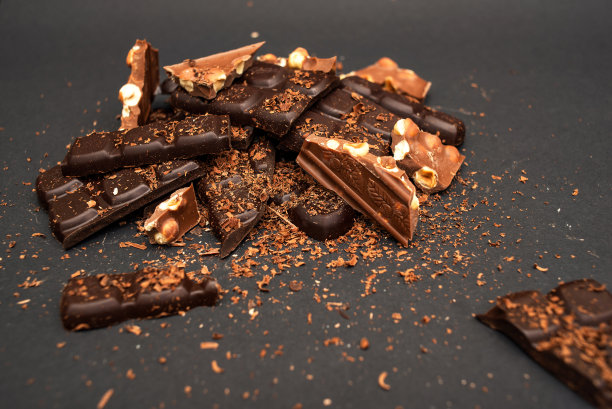 黑色背景上的黑巧克力和牛奶巧克力碎片，特写图片下载
