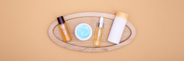 化妆品放在橘色背景的木托盘上。面部、身体和头发护理的概念。图片下载