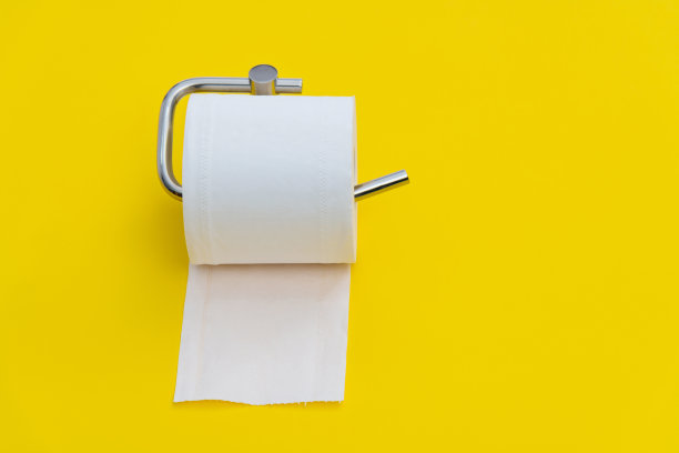 黄色背景上挂着一卷白色厕纸图片下载