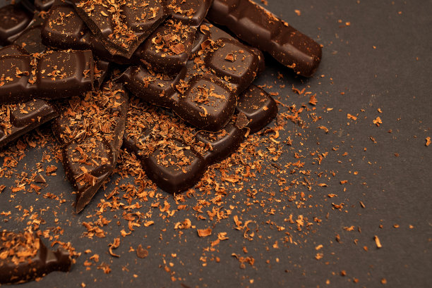 黑色背景上的黑巧克力和牛奶巧克力碎片，特写图片下载