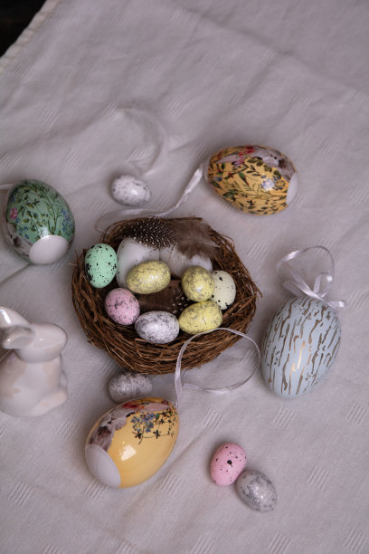一张白色桌布上的照片，上面有许多装饰性的鸡蛋和一只白色的复活节兔子图片下载