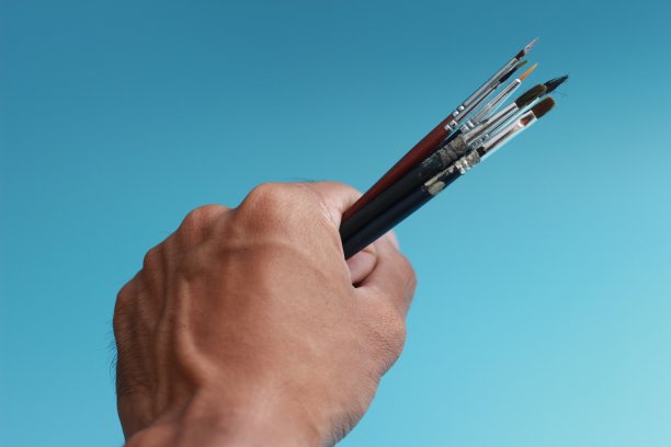 一个拿着画笔的手的特写图片下载