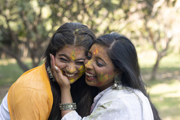 两个年轻的女孩姐妹朋友家庭庆祝享受胡里节的颜色在户外公园的一个流行的印度节日庆祝与古拉尔啤酒颜色粉图片下载