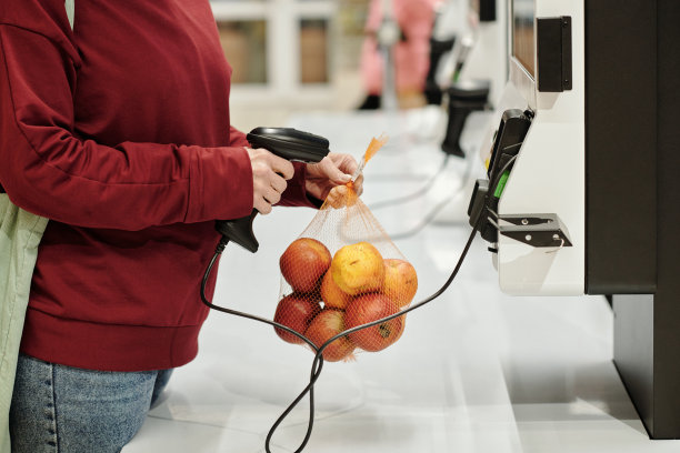 女性消费者在超市扫描包装好的苹果的特写图片下载