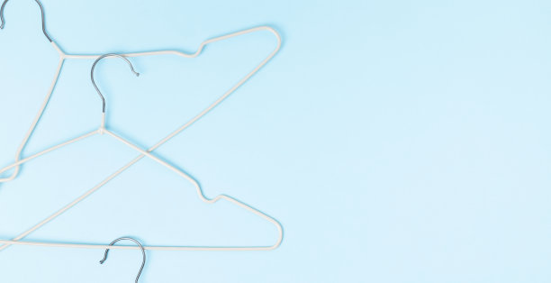 创意平铺衣架粉彩蓝色背景。销售折扣店促销购物概念。前视图。本空间图片下载