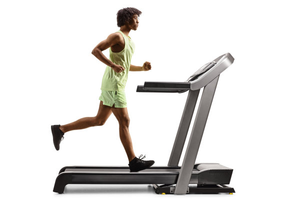 一个非裔美国人在跑步机上跑步的全长侧面照片图片下载