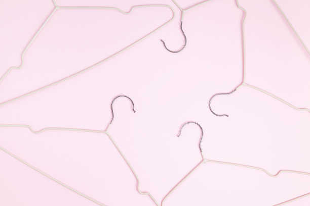 创意平铺衣架粉彩粉红色背景。销售折扣店促销购物概念。前视图。本空间图片下载