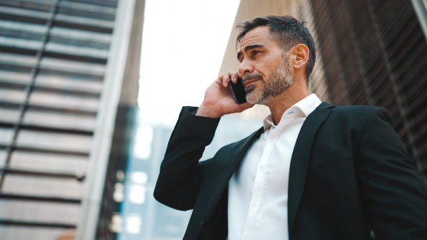 穿着办公服，留着整齐胡子的中年商人正在使用手机。成功男士在智能手机上深情交谈。失望,麻烦图片下载