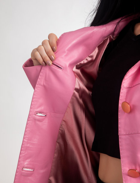 一位女士在炫耀她的粉色皮夹克。图片下载