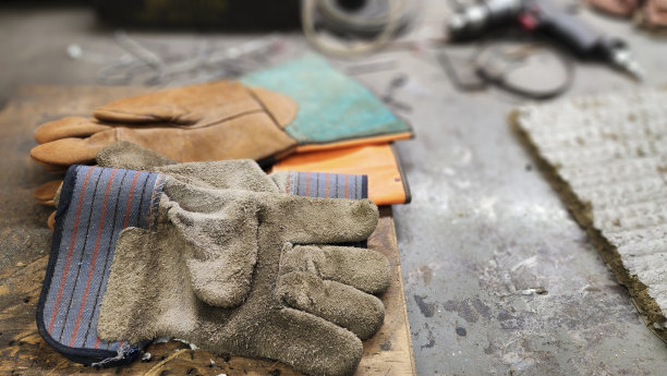 蓝领工人。工作台上戴安全手套。图片下载