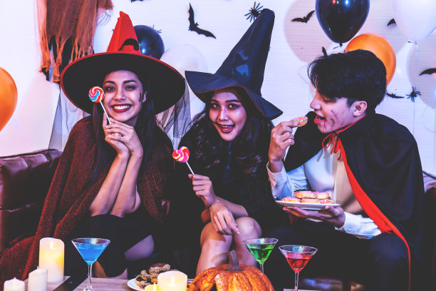 在万圣节的庆祝活动上，快乐的朋友们穿着戏服，化妆，享受美食，玩得很开心图片下载