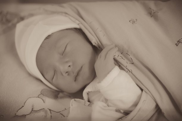 一个可爱的熟睡婴儿的灰度照片图片下载