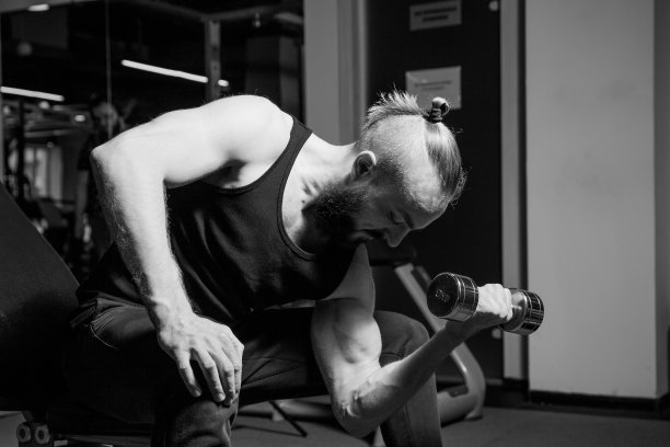 运动员在健身房用哑铃锻炼图片下载