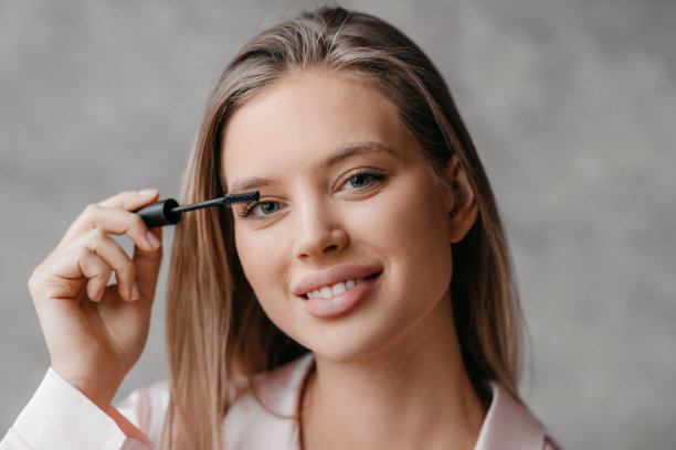 漂亮的女士用刷子刷睫毛膏的肖像，使用装饰性的化妆品，执行每天早上的例行公事图片下载
