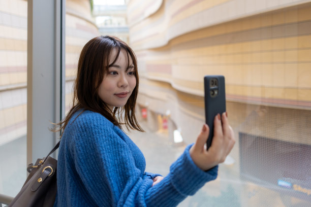 穿着蓝色毛衣的女子在城市里自拍图片下载