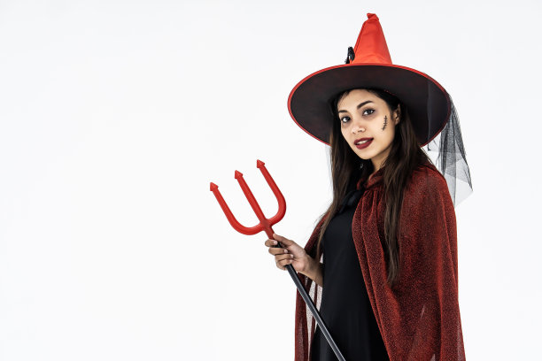万圣节派对女孩。快乐的万圣节女巫明亮的化妆和长发拿着武器图片下载