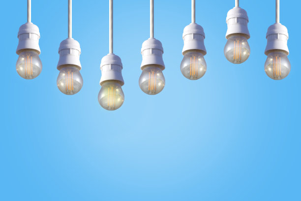 蓝色背景上的一排白色电灯泡。图片下载