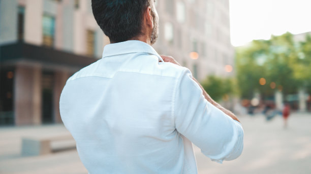 成熟的商人，留着整齐的胡子，整了整白衬衫，走在现代都市的街道上。成功的人轻松自在，享受生活图片下载