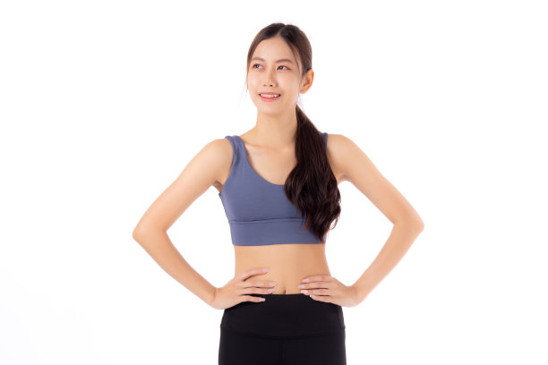 美丽的年轻亚洲女性的肖像在运动服微笑，显示腰部和腹肌孤立在白色背景上，运动和锻炼健康，女性苗条与自信和健康图片下载