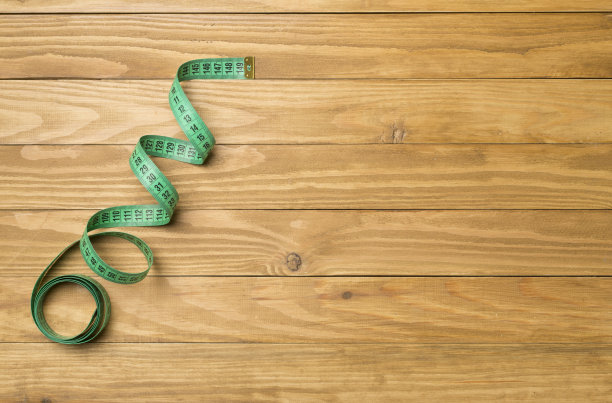 绿色卷尺在木制背景，俯视图图片下载