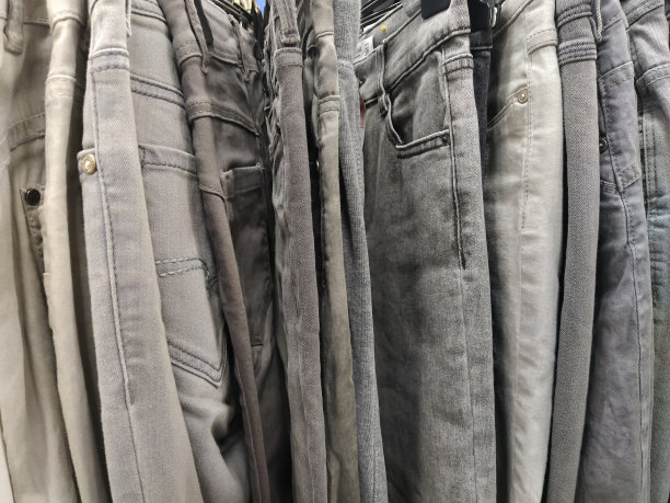 衣服挂在衣架上。二手商店的分类。衣服挂在架子上，准备出售给顾客。在危机中存钱。廉价的购物。牛仔裤和裤子。图片下载