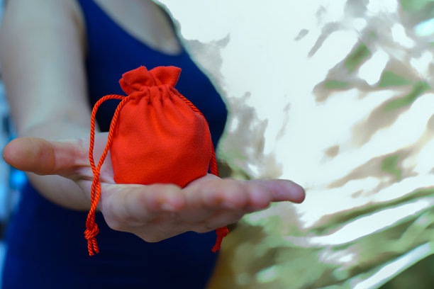 女孩伸出的手上放着红色的礼物袋图片下载