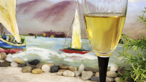 香槟长笛在桌子上的前景。帆船在软焦点背景。图片下载