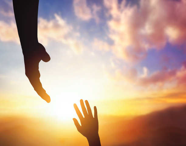 夕阳背景下，伸出援手，希望和互相支持的剪影。图片下载