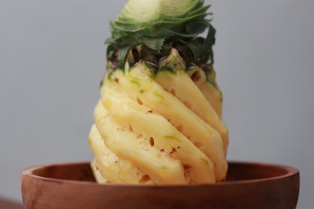 一个近距离的剥菠萝在一个木碗。水果照片概念。图片下载