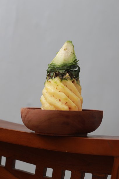 一个近距离的剥菠萝在一个木碗。水果照片概念。图片下载