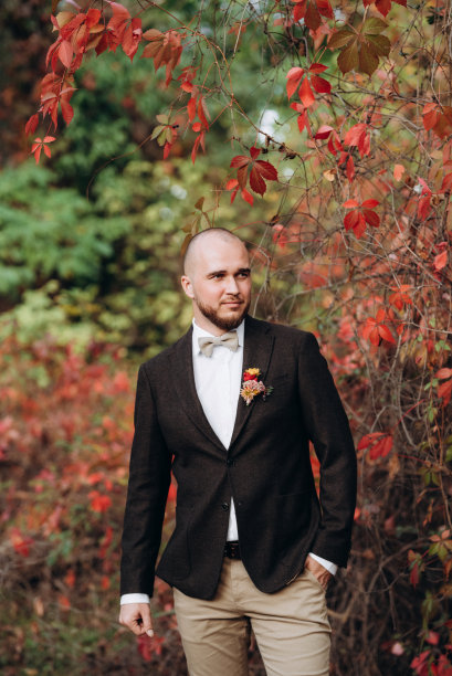 留着胡子的秃头，穿着棕色夹克，背景是红葡萄图片下载