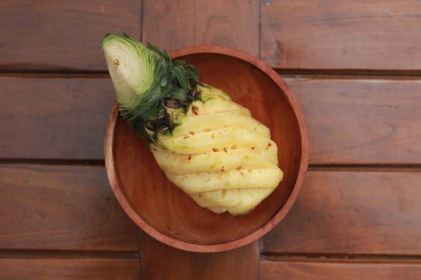 一个近距离的剥菠萝在一个木碗。水果照片概念。图片下载