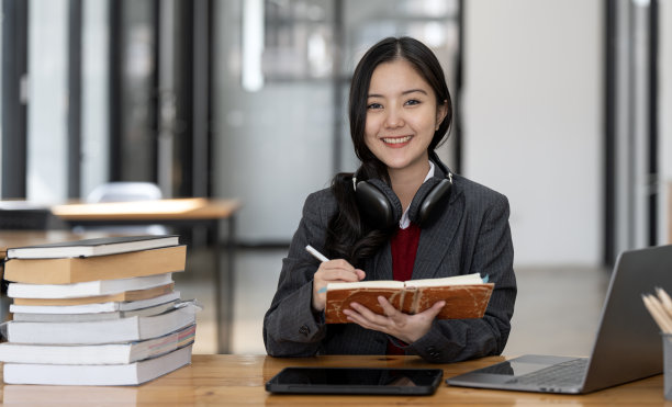 年轻的阿舍女大学生在图书馆的笔记本电脑上学习和工作。图片下载