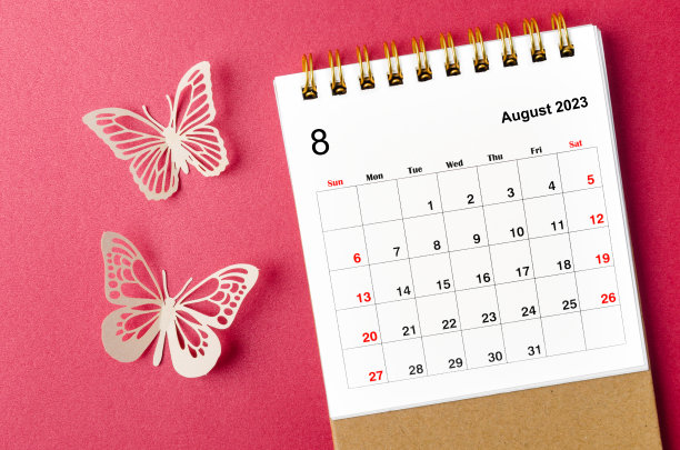 2023年8月日历桌，供组织者规划和提醒，红色背景上有蝴蝶纸。图片下载