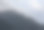 黑暗的大气超现实景观，在灰色多云的天空中，一个黑暗的岩石山峰在低云中。图片下载