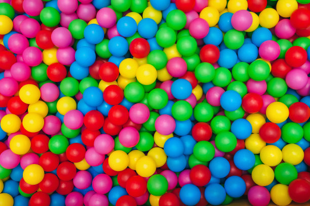 在儿童室内游乐场的球池中，可以看到许多五彩缤纷的塑料球。休闲娱乐理念。图片下载